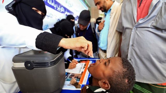 طفل يمني يتلقى لقاح الكوليرا عن طريق الفم من متطوعي السلطات الصحية خلال حملة تطعيم في صنعاء عام 2019